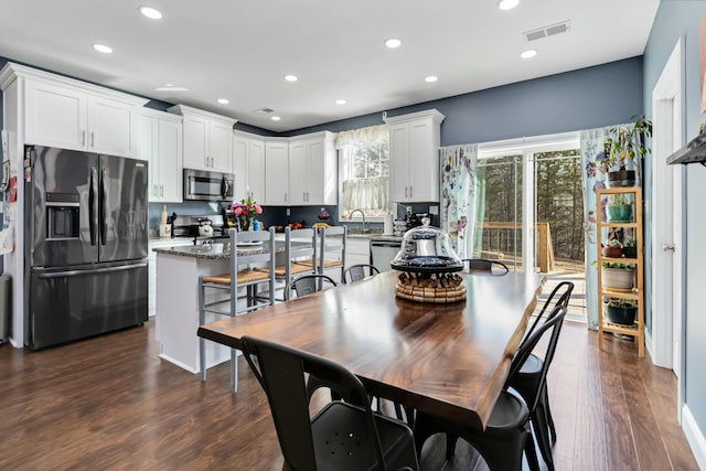 dining area featuring sink and dark hardwood / wood-style floors