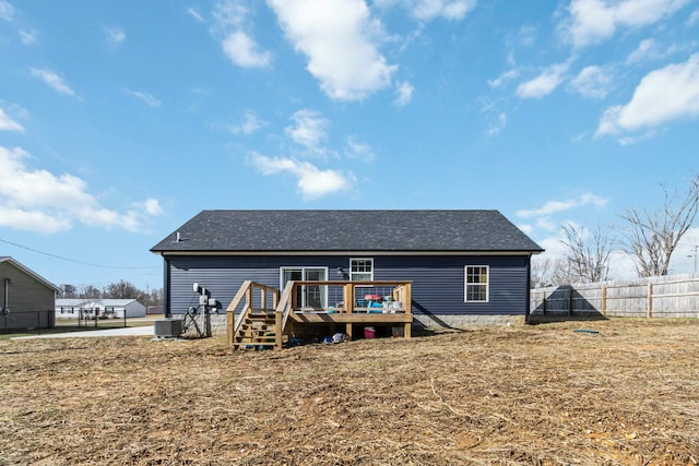 back of property featuring a deck, cooling unit, and a lawn