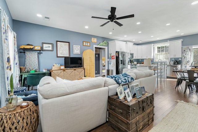 living room with ceiling fan and dark hardwood / wood-style floors