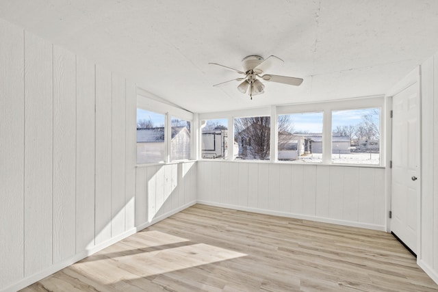 unfurnished sunroom featuring ceiling fan