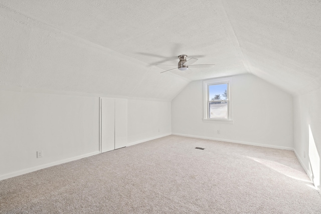 bonus room with ceiling fan, carpet flooring, a textured ceiling, and lofted ceiling