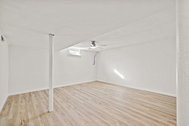 basement featuring ceiling fan and light hardwood / wood-style flooring