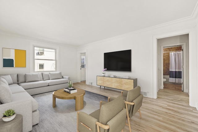 living room with light wood-type flooring and crown molding