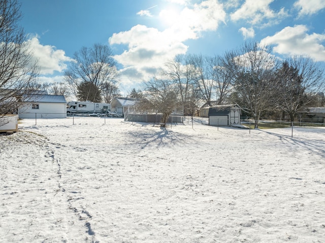 yard covered in snow with a storage unit