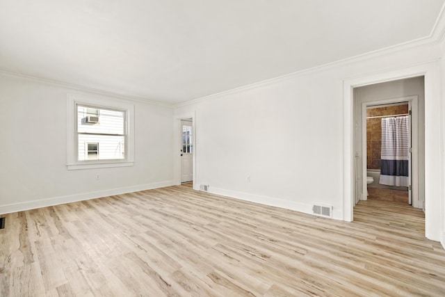 spare room with light wood-type flooring and crown molding