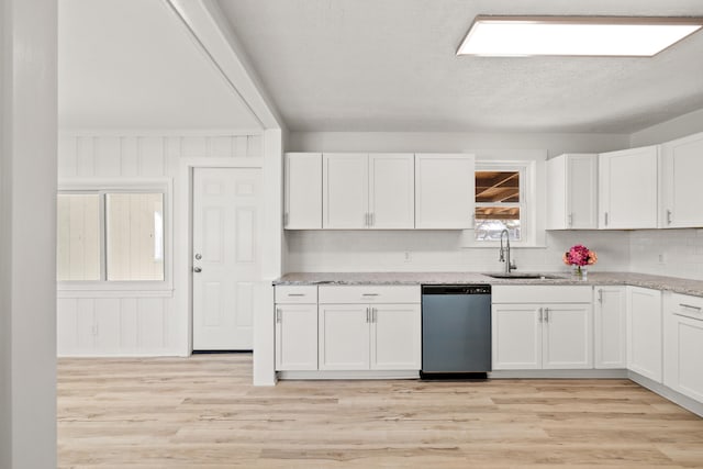 kitchen with sink, stainless steel dishwasher, white cabinetry, and light stone countertops