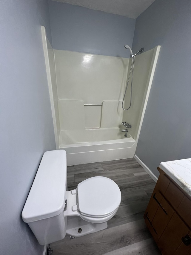 full bathroom with  shower combination, toilet, vanity, and wood-type flooring