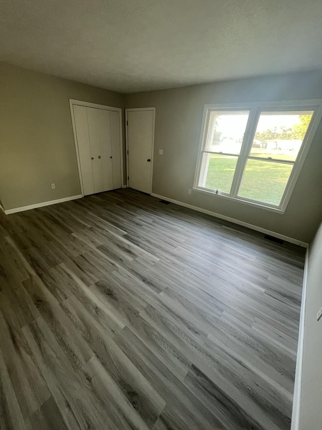 unfurnished bedroom with a textured ceiling and hardwood / wood-style floors