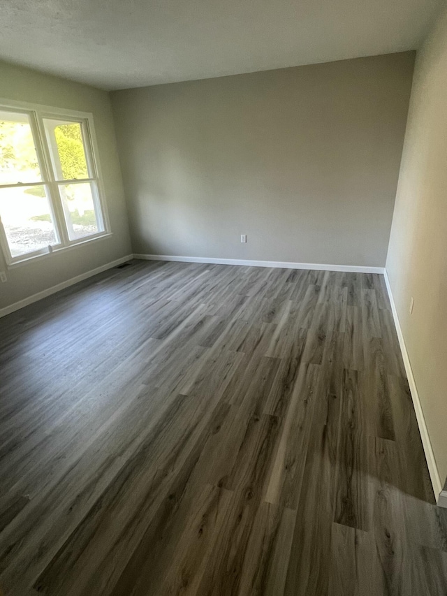 empty room with dark hardwood / wood-style flooring