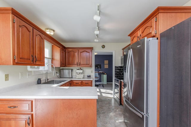 kitchen with kitchen peninsula, stainless steel appliances, track lighting, and sink