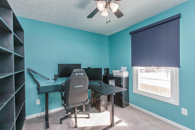 carpeted office space with ceiling fan and a textured ceiling