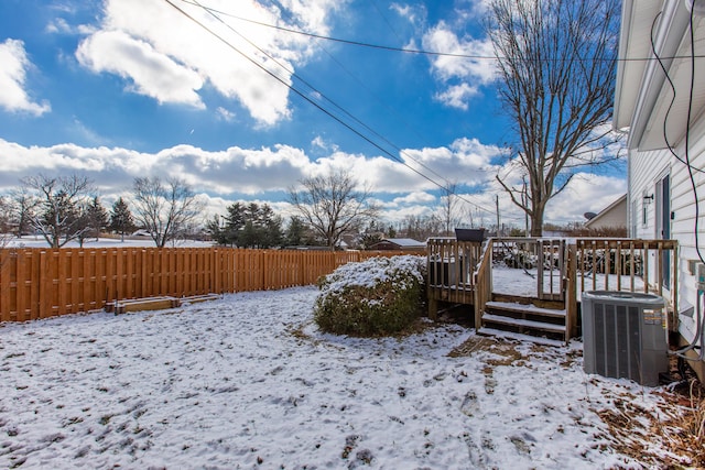 yard layered in snow featuring cooling unit and a wooden deck