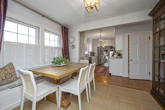 dining room with light wood-type flooring and a notable chandelier