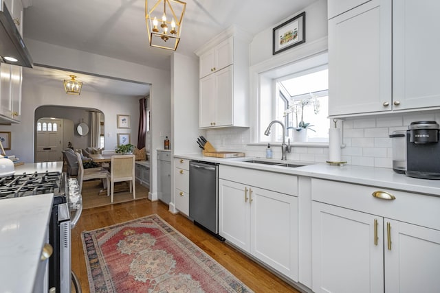 kitchen featuring dark hardwood / wood-style flooring, sink, exhaust hood, appliances with stainless steel finishes, and white cabinets