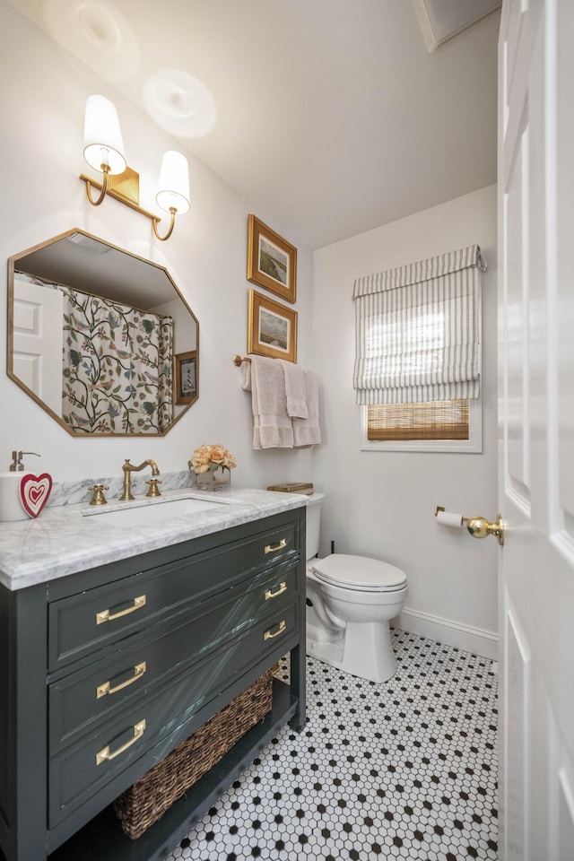 bathroom with toilet, tile patterned floors, and vanity