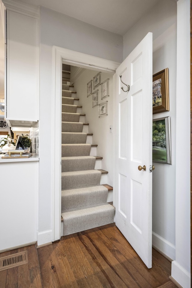 stairs featuring hardwood / wood-style floors