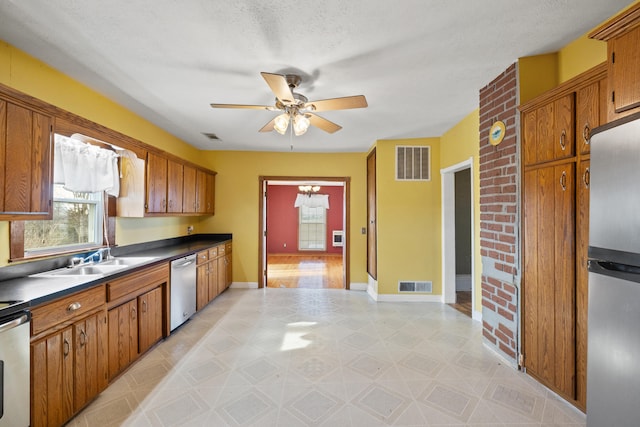 kitchen featuring dark countertops, brown cabinetry, visible vents, and stainless steel appliances