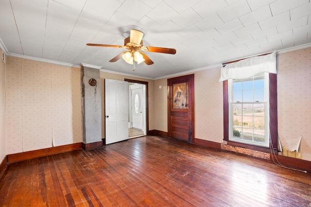 empty room featuring baseboards, ornamental molding, dark wood finished floors, and wallpapered walls