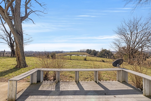 wooden deck featuring a yard and a rural view