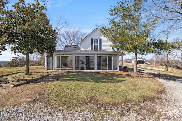 rear view of property with a sunroom and a yard