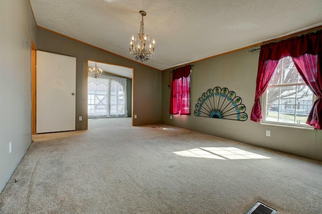 unfurnished room with a chandelier, ornamental molding, vaulted ceiling, and a textured ceiling