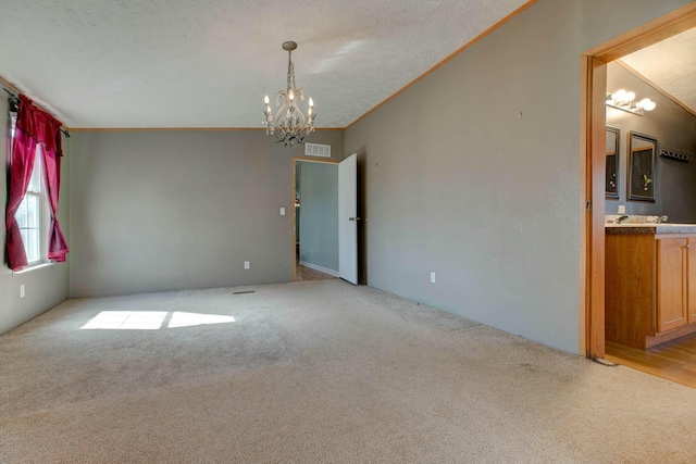 empty room featuring ornamental molding, light colored carpet, visible vents, and an inviting chandelier