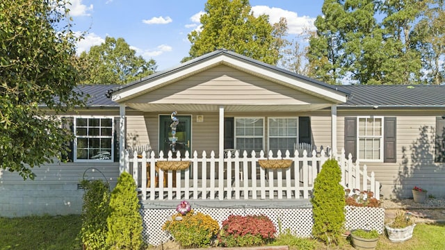 ranch-style home featuring a porch and metal roof