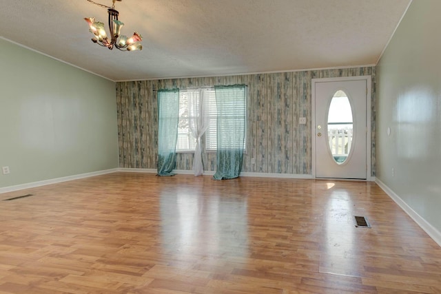 interior space with a chandelier, visible vents, and crown molding