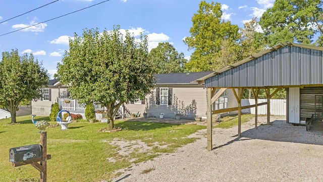 view of front of property with a carport, a front yard, metal roof, and driveway