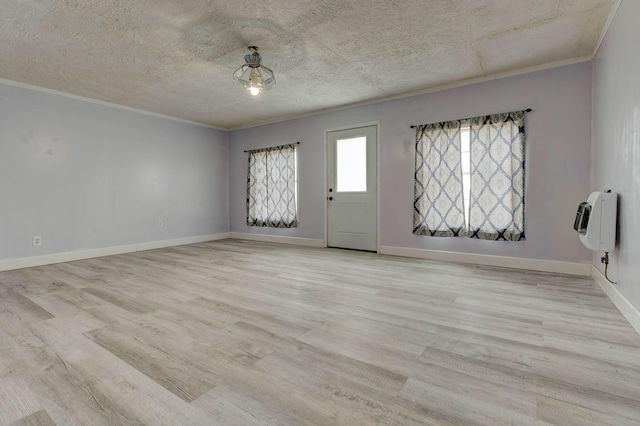 interior space with baseboards, ornamental molding, light wood-style floors, and heating unit