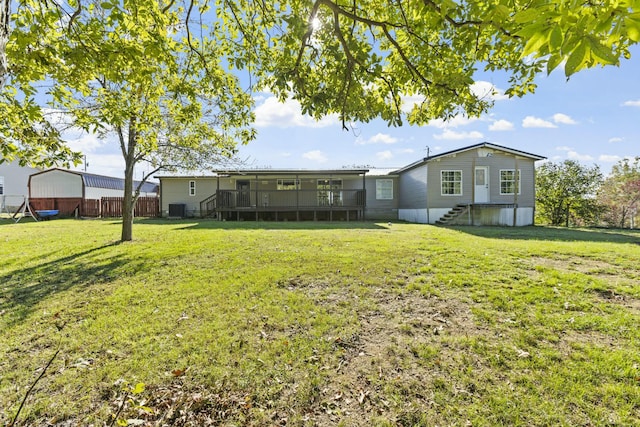 rear view of property featuring a lawn, fence, a sunroom, and central air condition unit