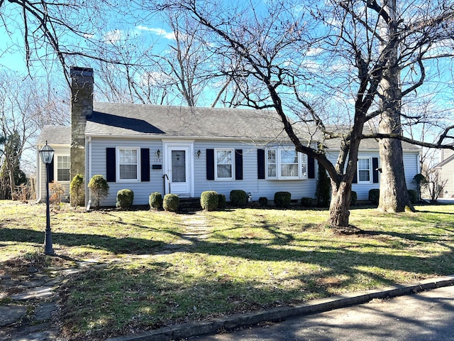 single story home with a shingled roof, entry steps, a chimney, and a front lawn