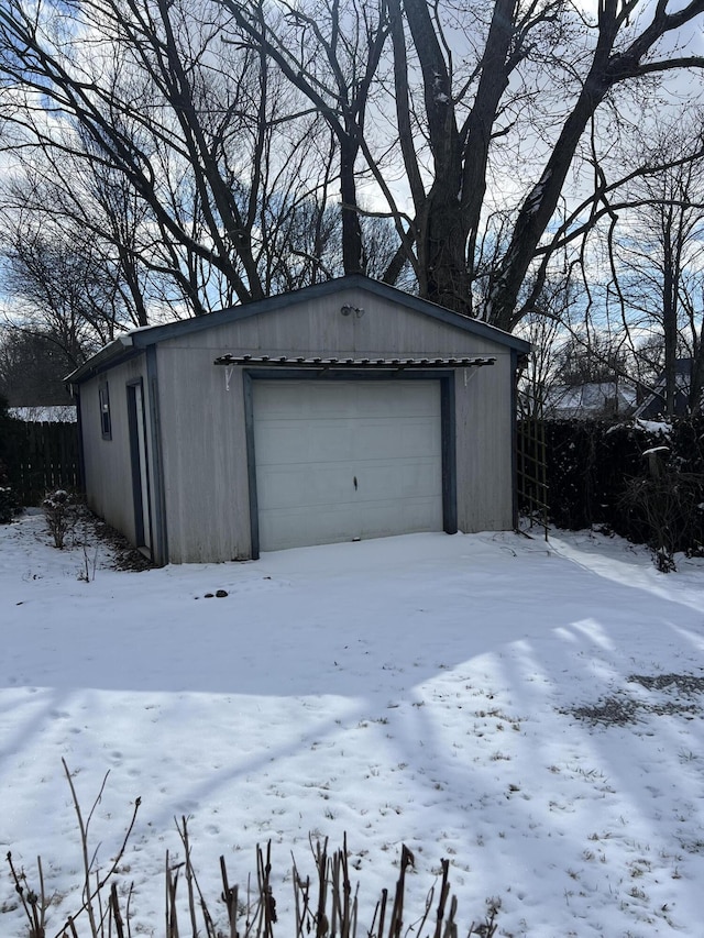 snow covered garage with a detached garage