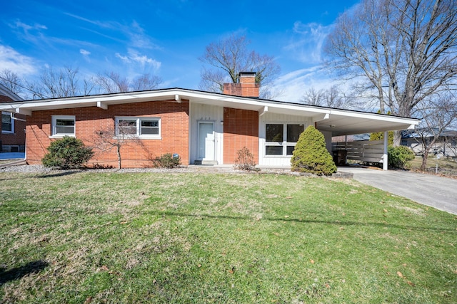 view of front of property featuring an attached carport, aphalt driveway, brick siding, a front lawn, and a chimney