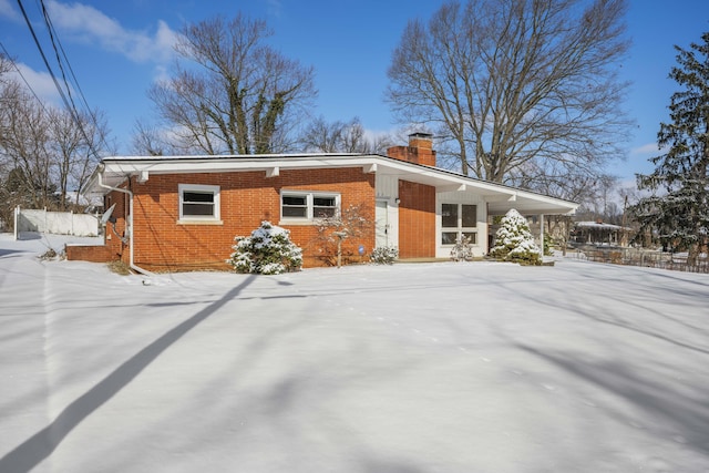 view of front of house featuring brick siding and a chimney