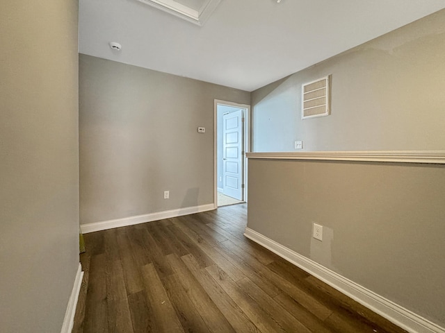 unfurnished room featuring visible vents, baseboards, and wood finished floors