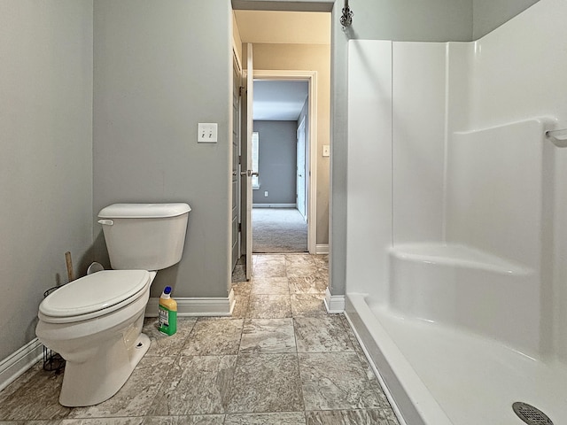 full bath with toilet, baseboards, and walk in shower