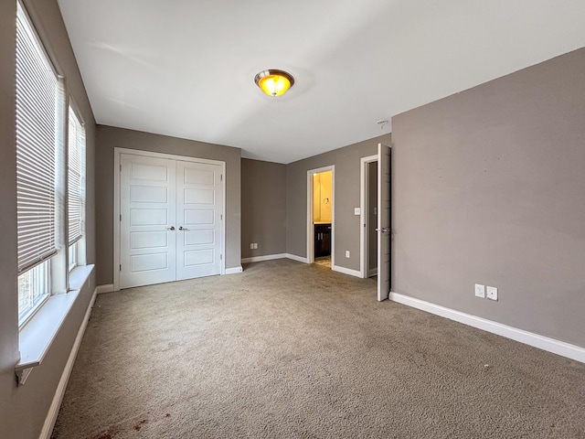 unfurnished bedroom featuring carpet floors, baseboards, and a closet