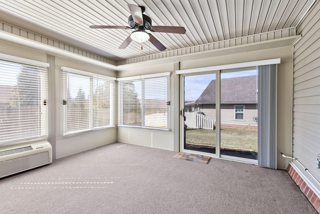 unfurnished sunroom featuring a healthy amount of sunlight, ceiling fan, and a wall unit AC