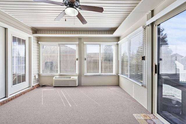 unfurnished sunroom featuring ceiling fan and a wall mounted air conditioner