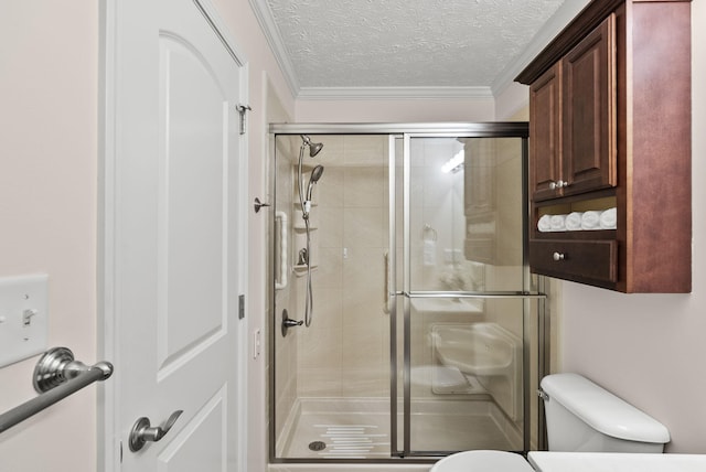 bathroom with a textured ceiling, ornamental molding, a stall shower, and toilet