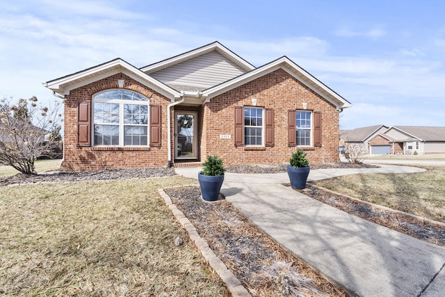 ranch-style house with a front yard and brick siding