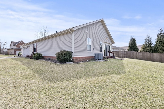 view of side of home with a garage, central AC, a lawn, and fence