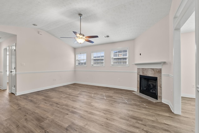 unfurnished living room with baseboards, a fireplace, visible vents, and wood finished floors