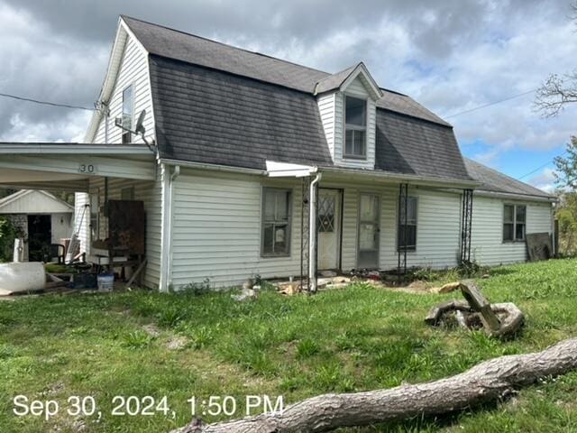 view of front of home featuring a carport and a front lawn