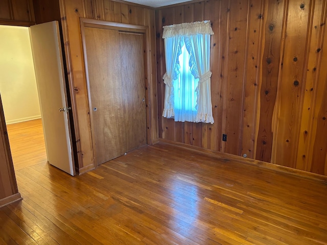 empty room with wood walls and wood finished floors