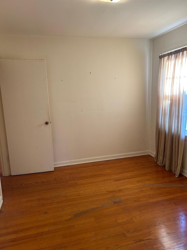 unfurnished room featuring baseboards and wood finished floors