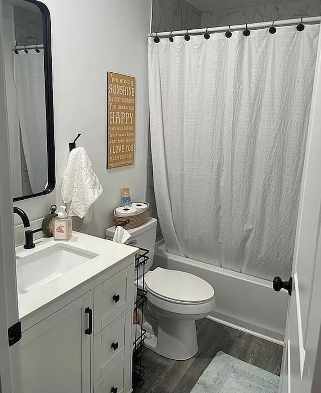 full bathroom featuring toilet, shower / bath combo, wood finished floors, and vanity