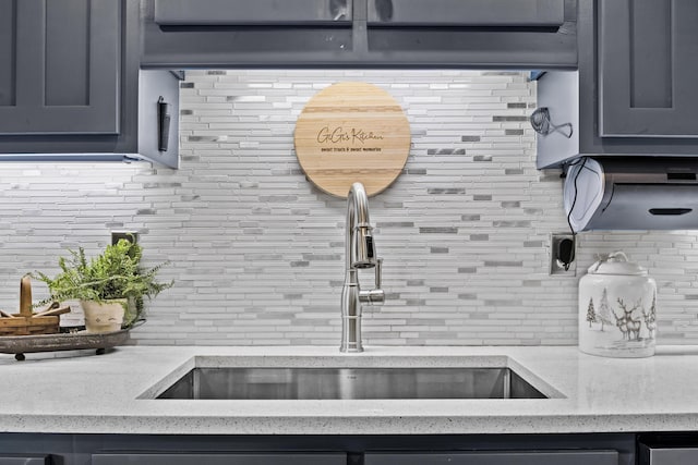 kitchen featuring backsplash, a sink, and light stone countertops