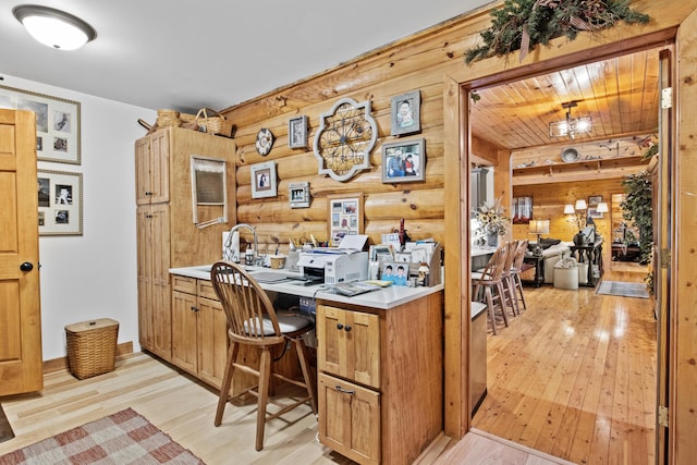 office space with log walls and light wood-style flooring